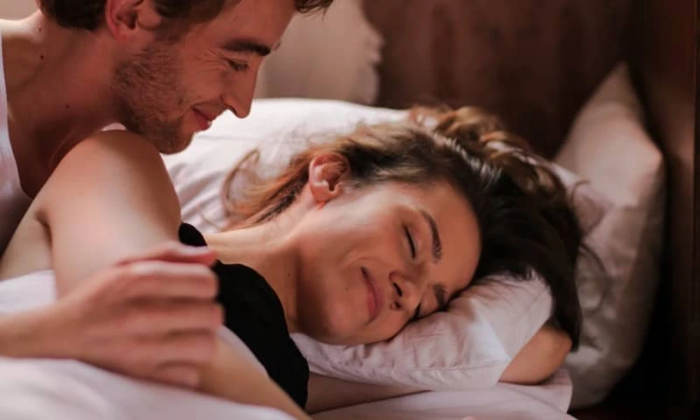 couple enjoying intimate moment on bed, highlighting natural lubrication tips